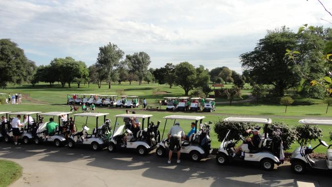Photo of golf course with golfers and golf carts