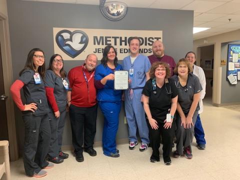 Methodist Jennie Edmundson Team posting in front of hospital sign for Hidden Halo Award