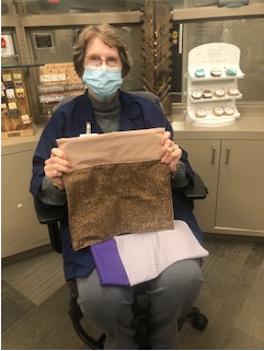 Irene Brucker; member of the sewing committee, holding a walker bag for physical therapy patients.